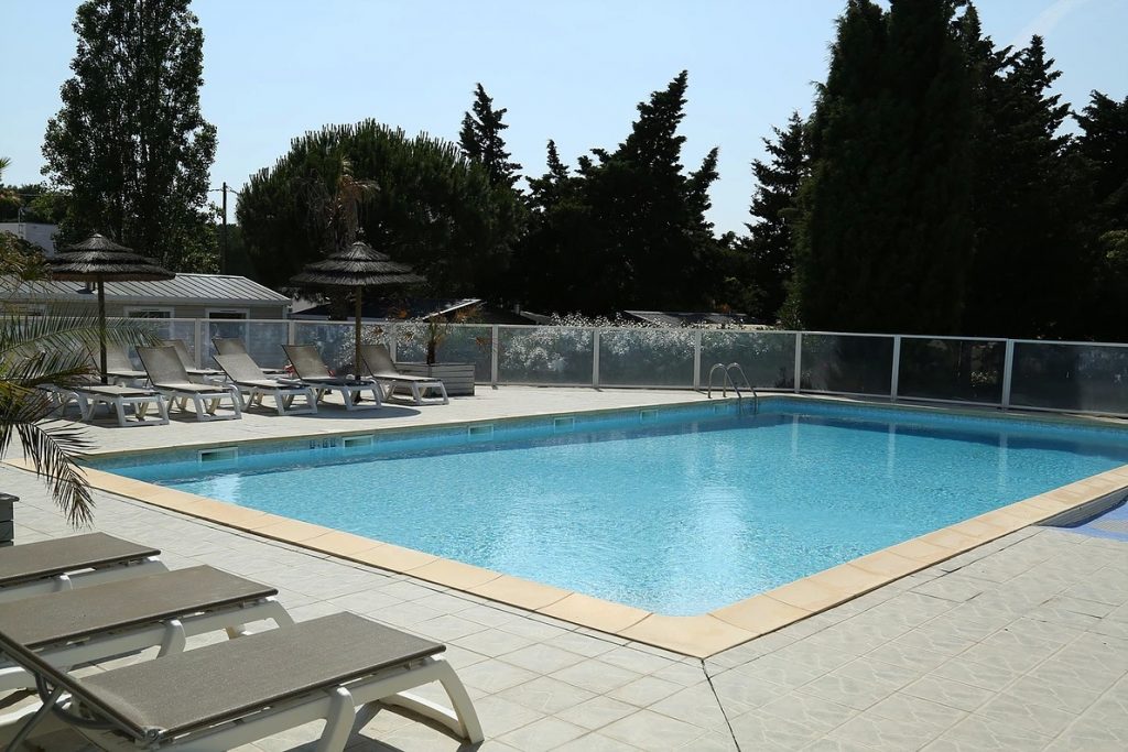 Vue de la piscine et des transats du Camping 3 étoiles Les Roches d'Agde